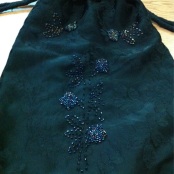 mochila de damasco negro, bordada en azul y amarillo con cortadillo creando rosas . mochila de cordones.